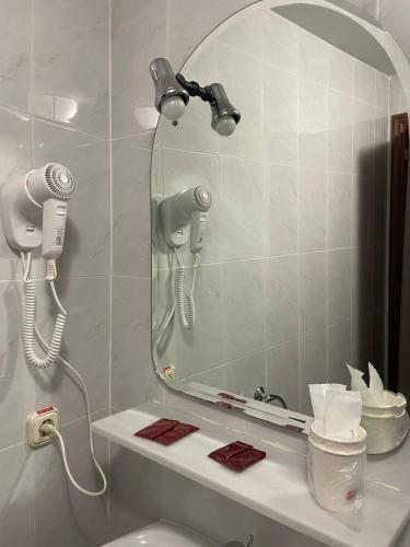 a bathroom with a mirror and a blow dryer at Pensión Capital de Galicia in Santiago de Compostela