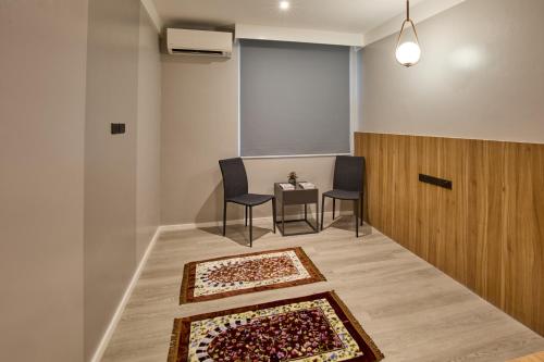 a room with two chairs and a table with two rugs at Go Hotels Plus Bacolod - Newly Renovated in Bacolod