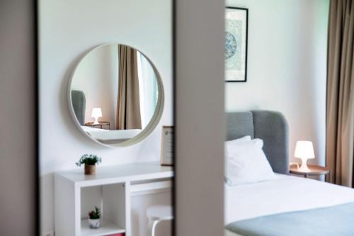 a bedroom with a bed and a mirror at Residenza Ticino by Quokka 360 - Modern Oasis near Bellinzona in Bellinzona
