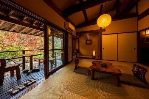 a living room with a table and a large window at Hozantei in Minamioguni