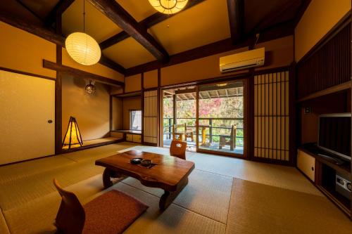 a living room with a wooden table in a room at Hozantei in Minamioguni