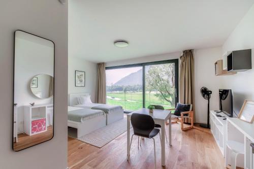 a bedroom with a bed and a table and a mirror at Residenza Ticino by Quokka 360 - Modern Oasis near Bellinzona in Bellinzona