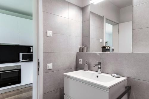 a bathroom with a sink and a mirror at Residenza Ticino by Quokka 360 - Modern Oasis near Bellinzona in Bellinzona