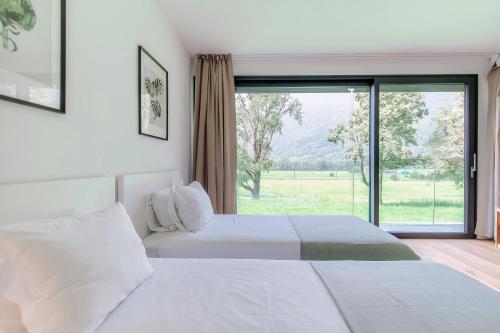 a bedroom with two beds and a large window at Residenza Ticino by Quokka 360 - Modern Oasis near Bellinzona in Bellinzona