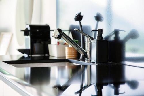 a counter with toothbrushes and other bathroom items on it at Residenza Ticino by Quokka 360 - Modern Oasis near Bellinzona in Bellinzona