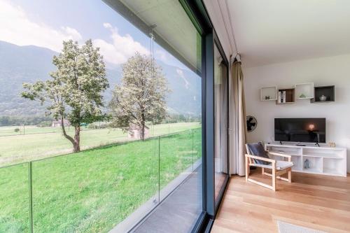 a room with a large window and a desk with a television at Residenza Ticino by Quokka 360 - Modern Oasis near Bellinzona in Bellinzona