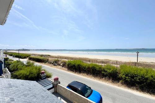 une voiture garée sur le côté d'une route à côté de la plage dans l'établissement Magnifique appartement vue mer Plage & charme, à Saint-Pierre-Quiberon