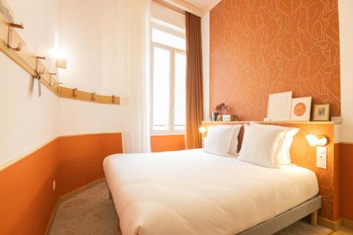 a bedroom with a bed with orange walls and a window at Grand Juste in Marseille