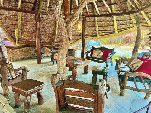 a room with chairs and tables in a straw building at Roy's Rest Camp in Groutfontein