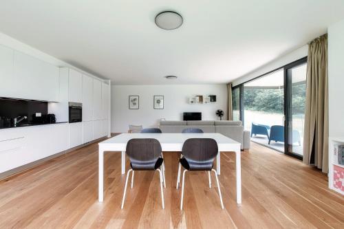 a dining room with a white table and chairs at Residenza Ticino by Quokka 360 - Modern Oasis near Bellinzona in Bellinzona