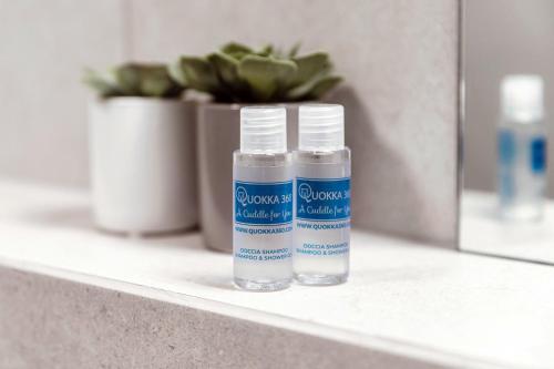 two bottles of water sitting on a shelf in front of a mirror at Residenza Ticino by Quokka 360 - Modern Oasis near Bellinzona in Bellinzona