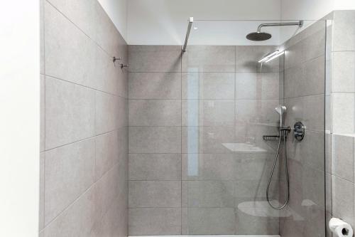a bathroom with a shower with a glass door at Residenza Ticino by Quokka 360 - Modern Oasis near Bellinzona in Bellinzona
