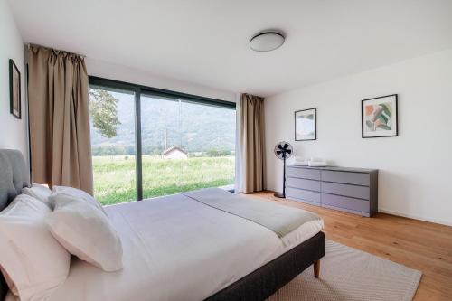 a bedroom with a large bed and a large window at Residenza Ticino by Quokka 360 - Modern Oasis near Bellinzona in Bellinzona