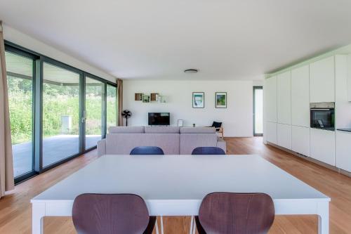 an open living room with a white table and chairs at Residenza Ticino by Quokka 360 - Modern Oasis near Bellinzona in Bellinzona