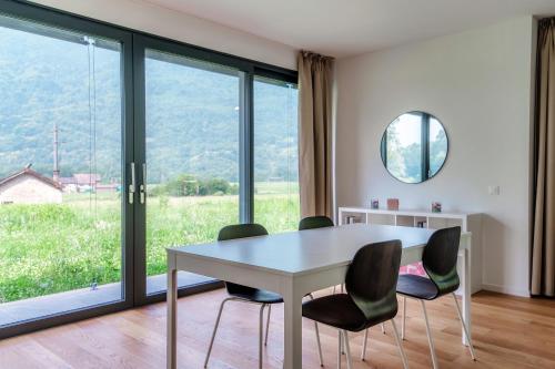 a dining room with a table and chairs and a window at Residenza Ticino by Quokka 360 - Modern Oasis near Bellinzona in Bellinzona