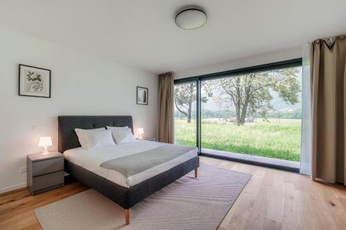a bedroom with a bed and a large window at Residenza Ticino by Quokka 360 - Modern Oasis near Bellinzona in Bellinzona