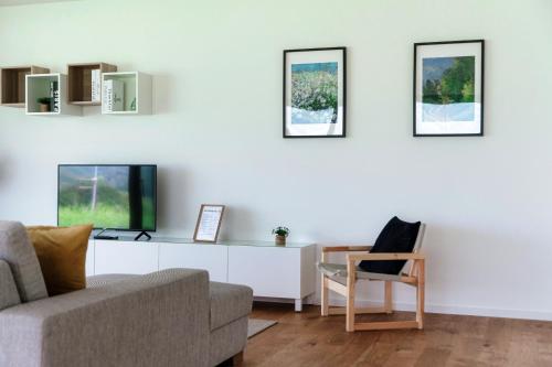 a living room with a couch and a tv at Residenza Ticino by Quokka 360 - Modern Oasis near Bellinzona in Bellinzona