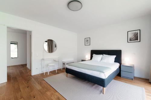 a white bedroom with a bed and a desk at Residenza Ticino by Quokka 360 - Modern Oasis near Bellinzona in Bellinzona