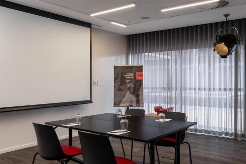 a meeting room with a black table and chairs at Radisson RED Hotel V&A Waterfront Cape Town in Cape Town