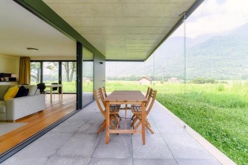 a room with a table and chairs on a patio at Residenza Ticino by Quokka 360 - Modern Oasis near Bellinzona in Bellinzona