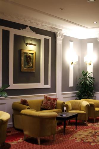 a living room with couches and chairs and a table at Radisson Blu GHR Rome in Rome