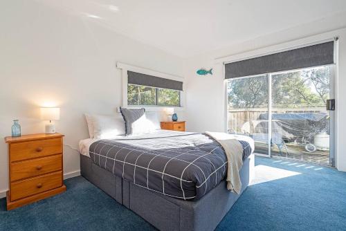 a bedroom with a bed and a large window at Seascape Cottage - Headland Stay near Whale Watching in Dodges Ferry