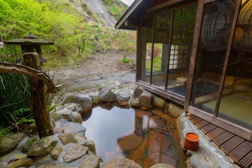 a small pond in front of a house at Hozantei in Minamioguni