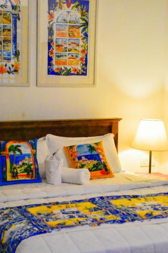 a bed with two pillows and a lamp on it at ArtNEST Gallery Stay , Pedlars St , Galle Fort in Galle