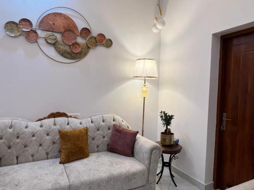 a living room with a couch and a lamp at Dyson Ville in Dehradun