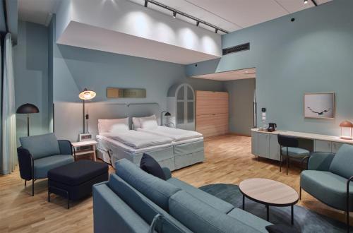 a room with a bed and a couch and a table at Scandic Göteborg Central in Gothenburg