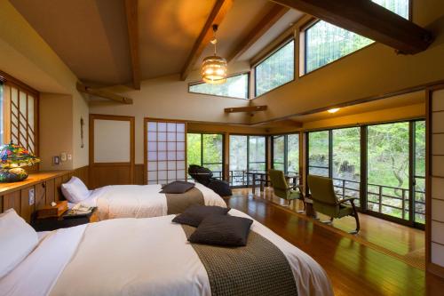 Habitación con 3 camas y ventanas. en Hozantei, en Minamioguni
