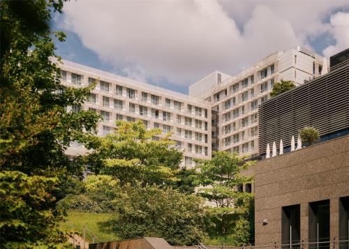 a large white building with trees in front of it at Lufthansa Seeheim - More than a Conference Hotel in Seeheim-Jugenheim