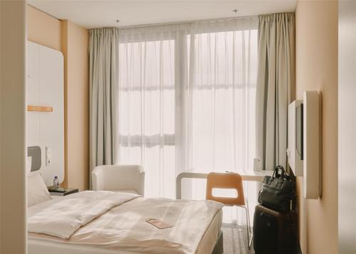 a hotel room with a bed and a window at Lufthansa Seeheim - More than a Conference Hotel in Seeheim-Jugenheim