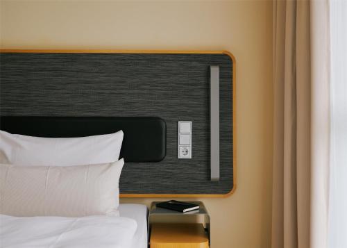 a hotel room with a bed with white pillows at Lufthansa Seeheim - More than a Conference Hotel in Seeheim-Jugenheim