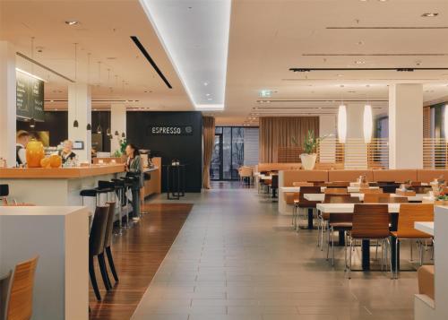 a restaurant with tables and chairs and a bar at Lufthansa Seeheim - More than a Conference Hotel in Seeheim-Jugenheim