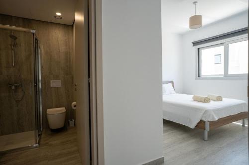a bedroom with a bed and a window and a shower at Modern Apartment, Walking Distance to Beach, Hot Tub, BBQ in Paphos City