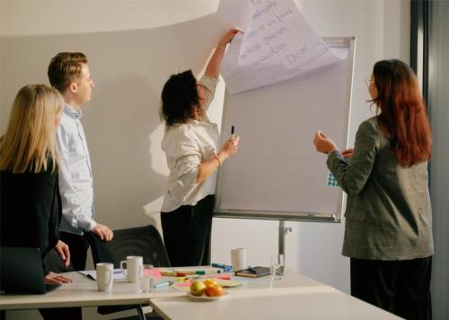 a group of people in an office writing on a whiteboard at Lufthansa Seeheim - More than a Conference Hotel in Seeheim-Jugenheim
