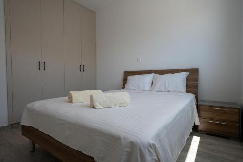 a bedroom with a large white bed with two towels on it at Modern Apartment, Walking Distance to Beach, Hot Tub, BBQ in Paphos City