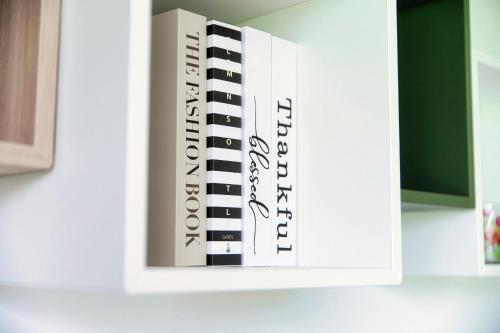 a stack of books sitting on top of a cabinet at Residenza Ticino by Quokka 360 - Modern Oasis near Bellinzona in Bellinzona