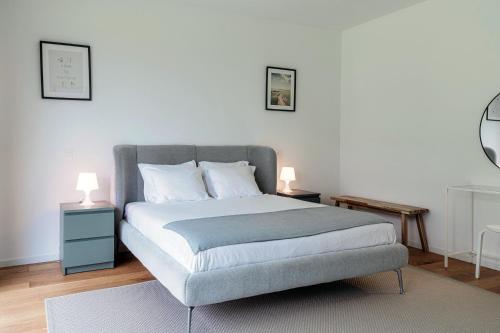 a bedroom with a bed with two tables and two lamps at Residenza Ticino by Quokka 360 - Modern Oasis near Bellinzona in Bellinzona