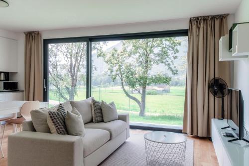 a living room with a couch and a large window at Residenza Ticino by Quokka 360 - Modern Oasis near Bellinzona in Bellinzona