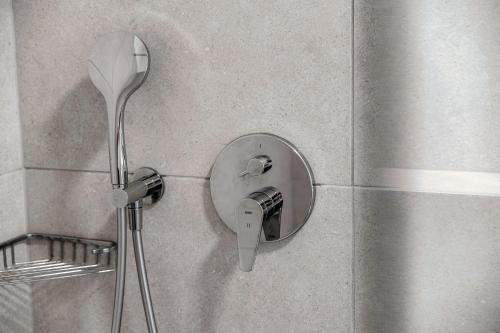 a shower head on a wall in a bathroom at Residenza Ticino by Quokka 360 - Modern Oasis near Bellinzona in Bellinzona