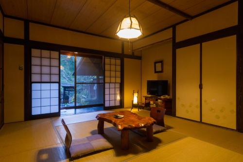 a living room with a table and chairs and a window at Hozantei in Minamioguni