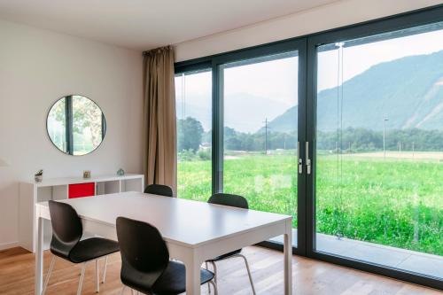 a white table and chairs in a room with a window at Residenza Ticino by Quokka 360 - Modern Oasis near Bellinzona in Bellinzona