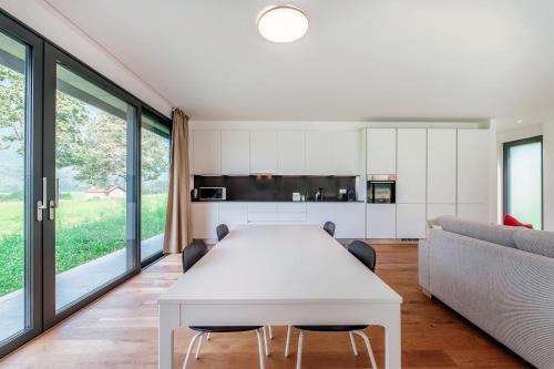 a dining room with a white table and a couch at Residenza Ticino by Quokka 360 - Modern Oasis near Bellinzona in Bellinzona