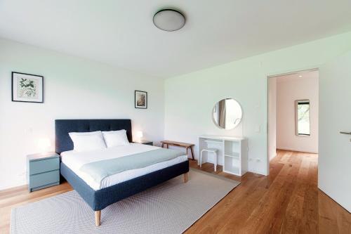 a white bedroom with a bed and a mirror at Residenza Ticino by Quokka 360 - Modern Oasis near Bellinzona in Bellinzona
