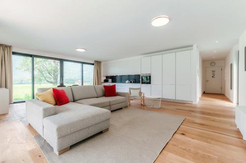 a living room with a couch and a kitchen at Residenza Ticino by Quokka 360 - Modern Oasis near Bellinzona in Bellinzona