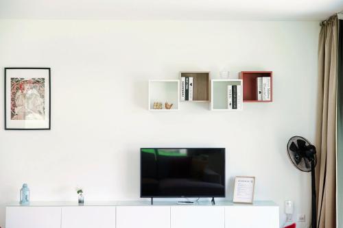 a living room with a tv on a white wall at Residenza Ticino by Quokka 360 - Modern Oasis near Bellinzona in Bellinzona