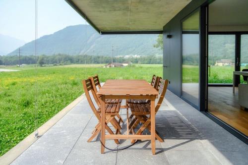 a wooden table and two chairs sitting on a patio at Residenza Ticino by Quokka 360 - Modern Oasis near Bellinzona in Bellinzona