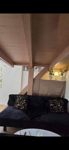 a black couch in a room with a ceiling at Sweet Escape -T1 bis romantique in Bourg-lès-Valence